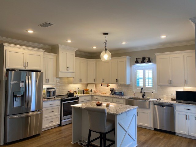 living room featuring coffered ceiling, crown molding, wood-type flooring, ceiling fan, and beam ceiling