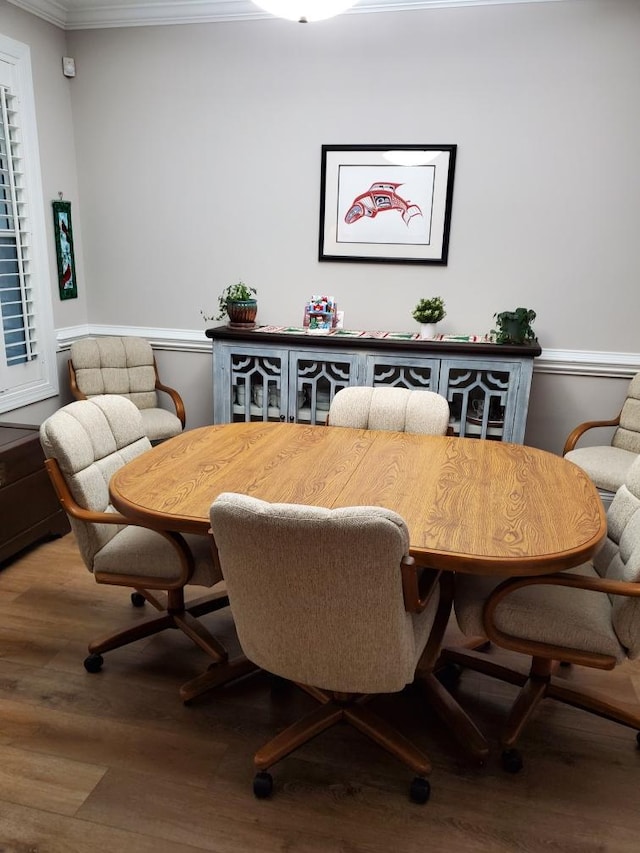 dining space with crown molding and wood-type flooring