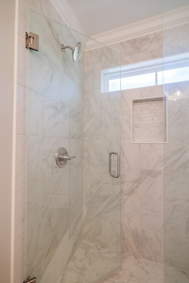 bathroom featuring ornamental molding and a shower with door