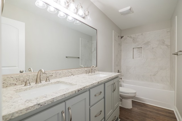 full bathroom with toilet, tiled shower / bath, wood-type flooring, and vanity