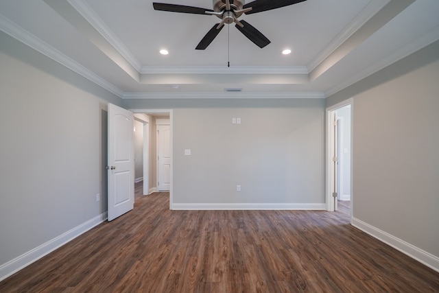 empty room with ceiling fan, dark wood-type flooring, a tray ceiling, and crown molding