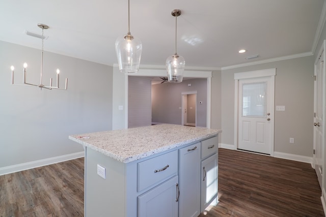 kitchen with decorative light fixtures, dark hardwood / wood-style floors, a center island, light stone countertops, and ornamental molding