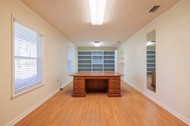 unfurnished office with a textured ceiling, light hardwood / wood-style flooring, and crown molding