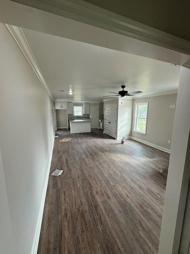 unfurnished living room with dark hardwood / wood-style floors, ceiling fan, and ornamental molding