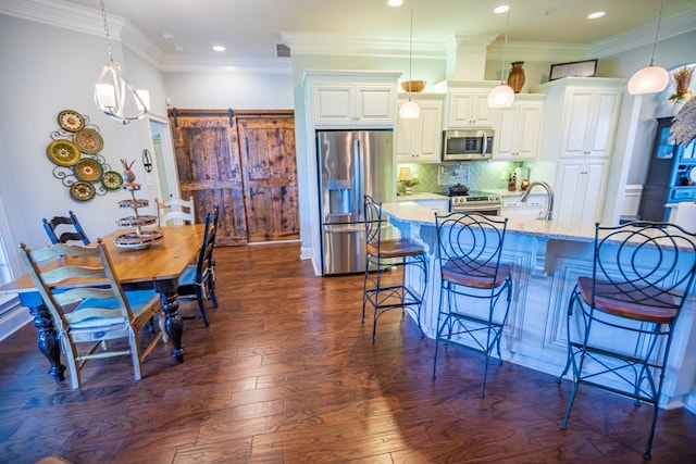 5643 Timberwind Cir, Lake Park, GA 31636 - kitchen featuring stainless steel appliances, a breakfast bar area, decorative backsplash, dark wood-style flooring, and recessed lighting