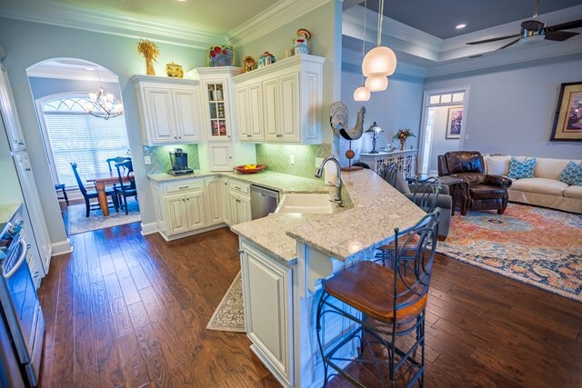5643 Timberwind Cir, Lake Park, GA 31636 - kitchen with a sink, arched walkways, a peninsula, dishwasher, and light stone counters