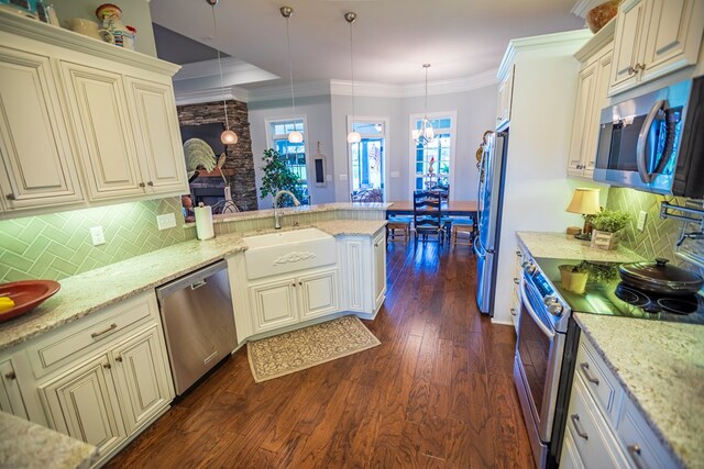 5643 Timberwind Cir, Lake Park, GA 31636 - kitchen featuring appliances with stainless steel finishes, a sink, cream cabinets, healthy amount of natural light, and crown molding