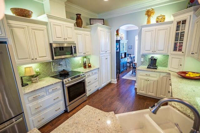 5643 Timberwind Cir, Lake Park, GA 31636 - kitchen with stainless steel appliances, arched walkways, tasteful backsplash, ornamental molding, and light stone countertops