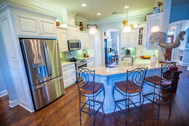 5643 Timberwind Cir, Lake Park, GA 31636 - kitchen featuring stainless steel appliances, arched walkways, a breakfast bar, light stone counters, and backsplash