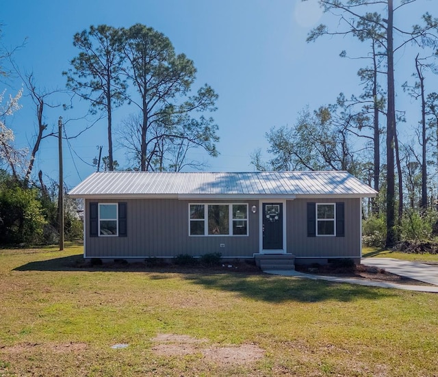 view of front of house with a front lawn and metal roof