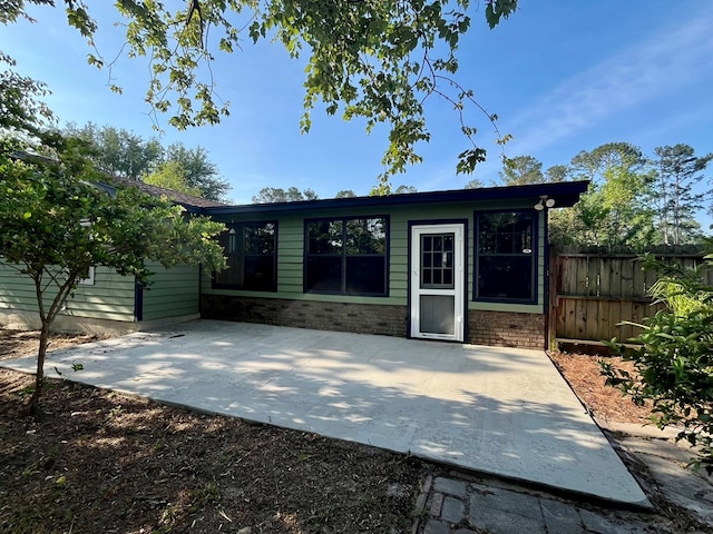 exterior space with a patio area, brick siding, and fence