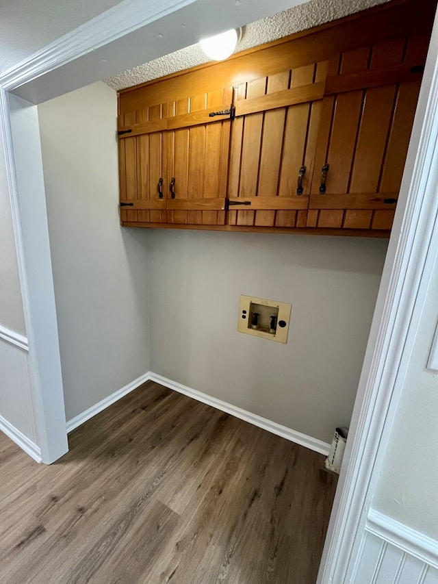 laundry room with cabinet space, washer hookup, dark wood-style flooring, and baseboards
