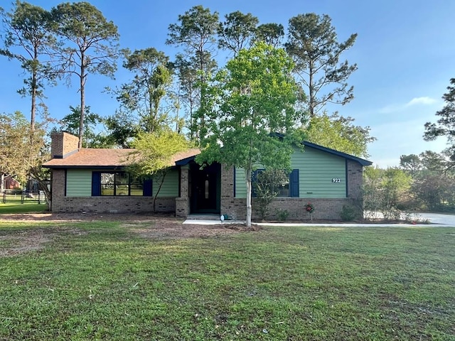 ranch-style house with a front lawn, a chimney, and brick siding