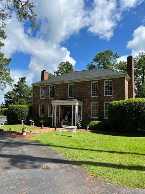 colonial home featuring a front yard