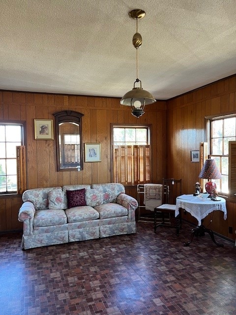 living room featuring a textured ceiling and wooden walls