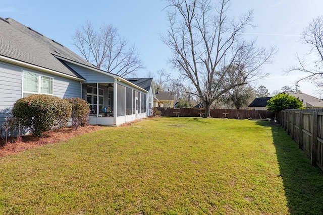 view of yard with a sunroom, a fenced backyard, and ceiling fan