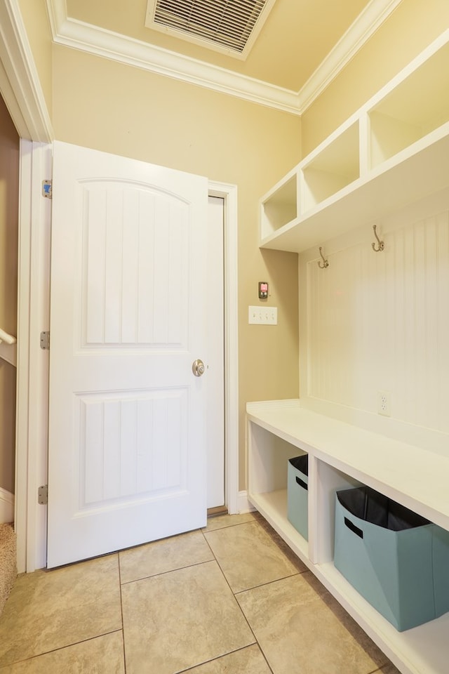 mudroom featuring visible vents, crown molding, and light tile patterned flooring