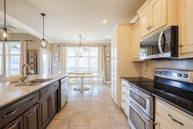 kitchen with tasteful backsplash, appliances with stainless steel finishes, ornamental molding, a sink, and light stone countertops