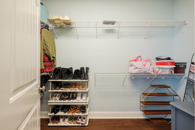 walk in closet with wood finished floors