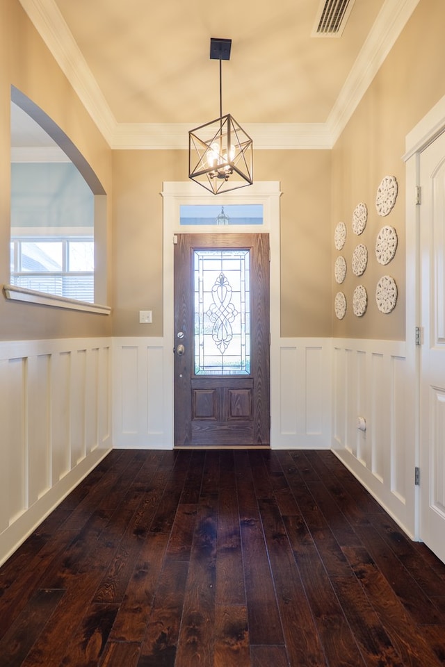 entryway featuring a wainscoted wall, ornamental molding, hardwood / wood-style flooring, and visible vents