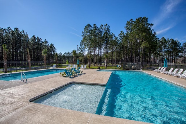 community pool with a patio and fence