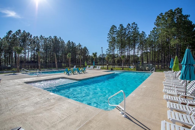 community pool with fence and a patio