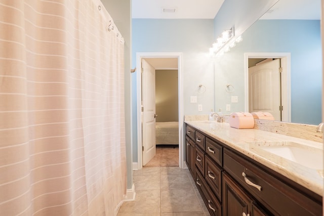 bathroom with a sink, double vanity, tile patterned flooring, and connected bathroom