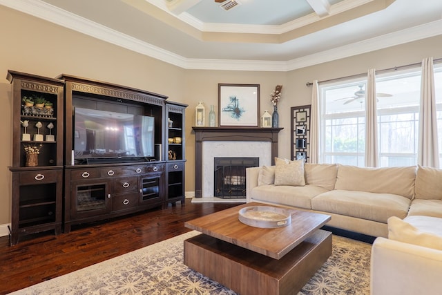 living room with visible vents, a ceiling fan, dark wood-style floors, ornamental molding, and a fireplace