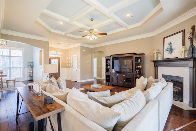 living room featuring arched walkways, coffered ceiling, a fireplace with flush hearth, ornamental molding, and dark wood-type flooring