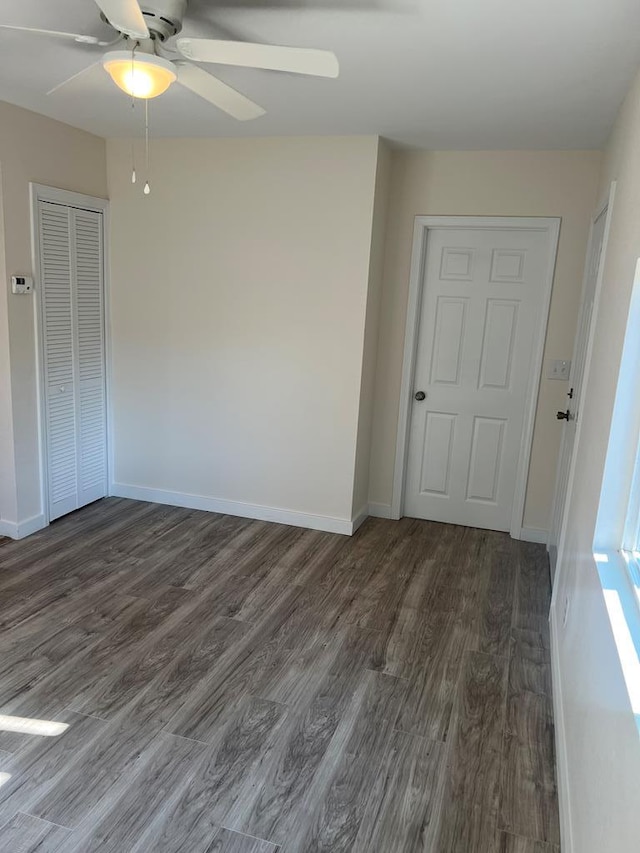 empty room with dark wood-type flooring and ceiling fan