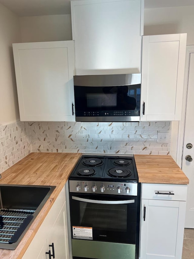 kitchen with white cabinetry, sink, wooden counters, backsplash, and stainless steel appliances