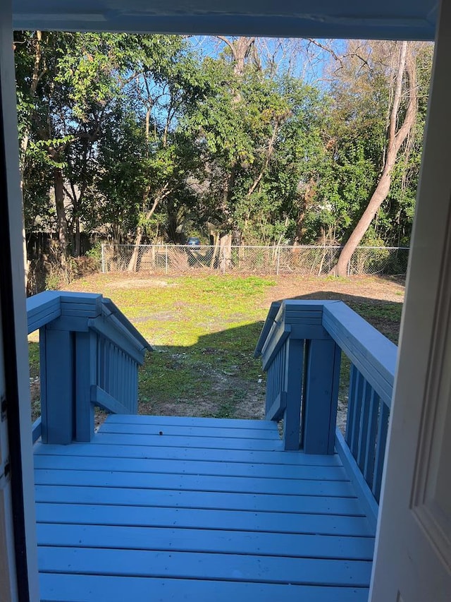 wooden deck featuring a lawn