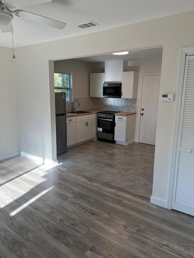 kitchen with sink, ceiling fan, appliances with stainless steel finishes, white cabinets, and decorative backsplash