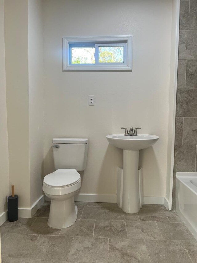 bathroom with a tub, sink, and toilet