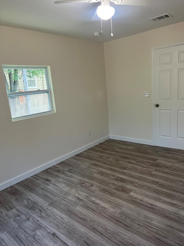 unfurnished room with dark wood-type flooring and ceiling fan