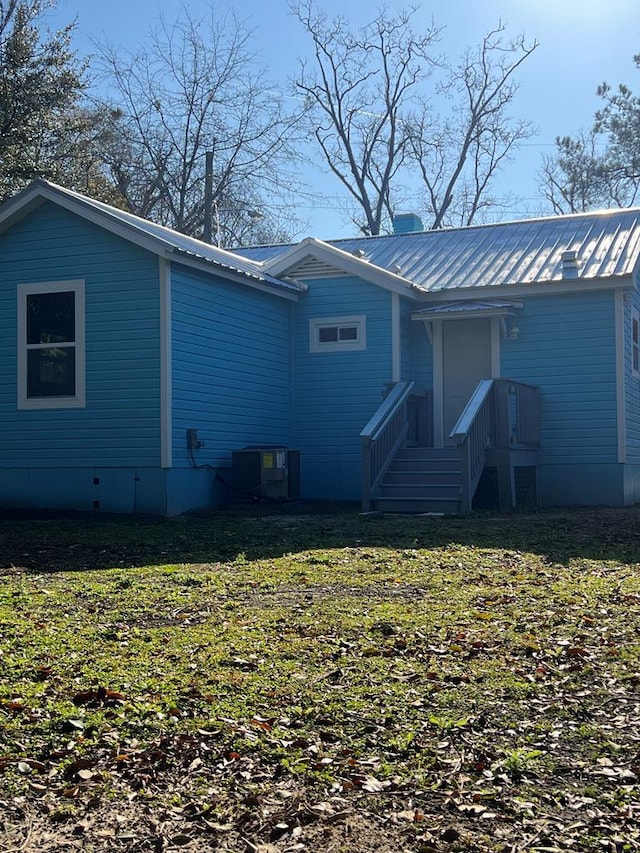 119 E Merrill St, Thomasville, GA 31792 - back of property featuring a yard, metal roof, central AC unit, and a chimney