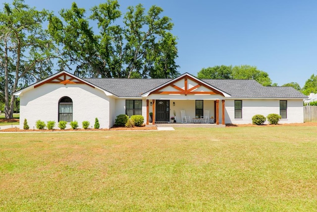 view of front of property featuring a shingled roof, a porch, and a front lawn