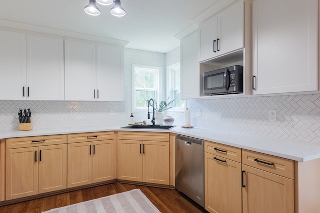 kitchen featuring a sink, light brown cabinets, dark wood-type flooring, backsplash, and stainless steel dishwasher