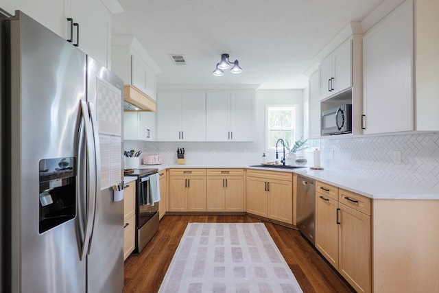 kitchen with a sink, backsplash, visible vents, and appliances with stainless steel finishes