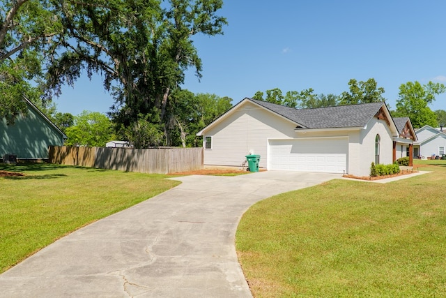 view of home's exterior featuring driveway, roof with shingles, a lawn, an attached garage, and fence