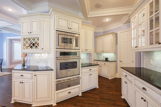 kitchen with ornamental molding, a warming drawer, cream cabinetry, decorative backsplash, and coffered ceiling