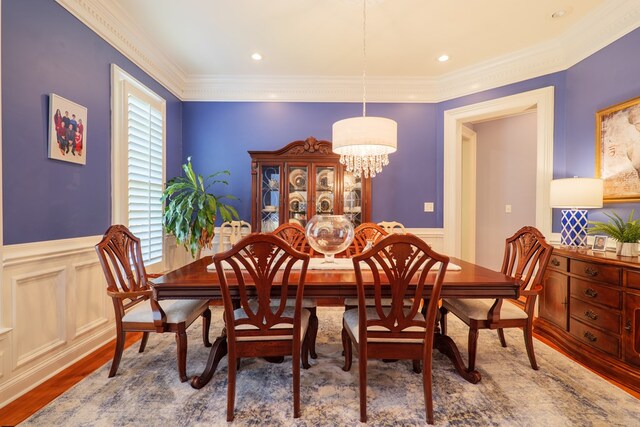 4333 Spring Branch Cir, Valdosta, GA 31601 - dining space with a chandelier, wood finished floors, crown molding, a wainscoted wall, and a decorative wall