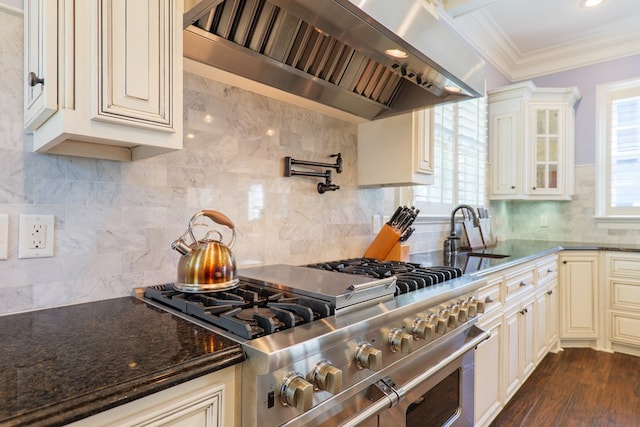 kitchen featuring range with two ovens, a sink, custom range hood, crown molding, and cream cabinets