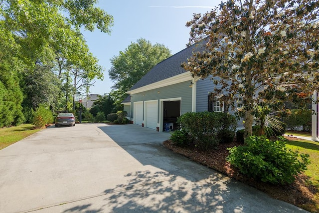 view of side of property featuring a shingled roof and driveway