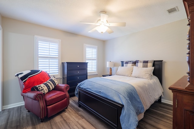 bedroom featuring visible vents, baseboards, and wood finished floors