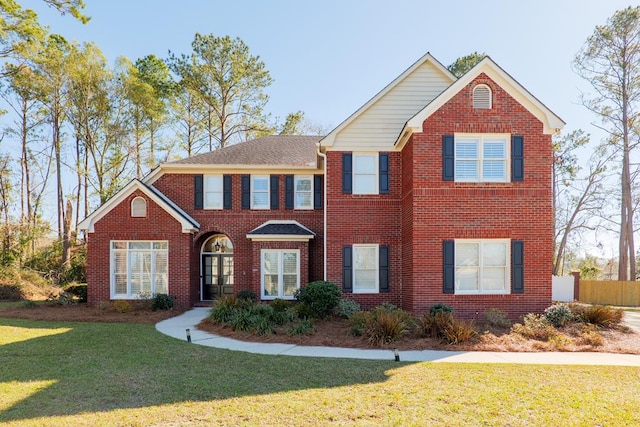 traditional-style house with fence, a front lawn, and brick siding