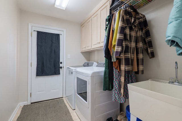 laundry area featuring light tile patterned floors, cabinet space, a sink, and separate washer and dryer