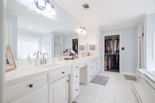 bathroom featuring a stall shower, visible vents, a walk in closet, and a sink