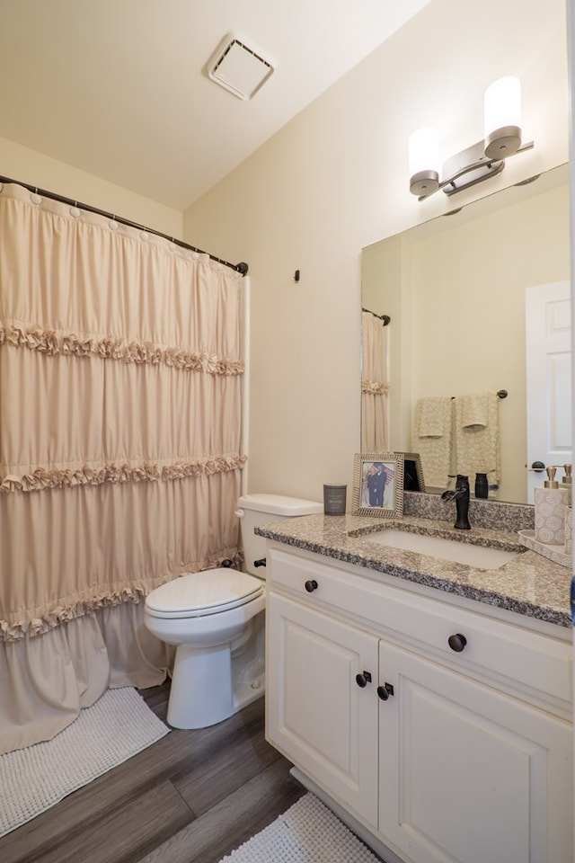 full bathroom with toilet, curtained shower, wood finished floors, and vanity