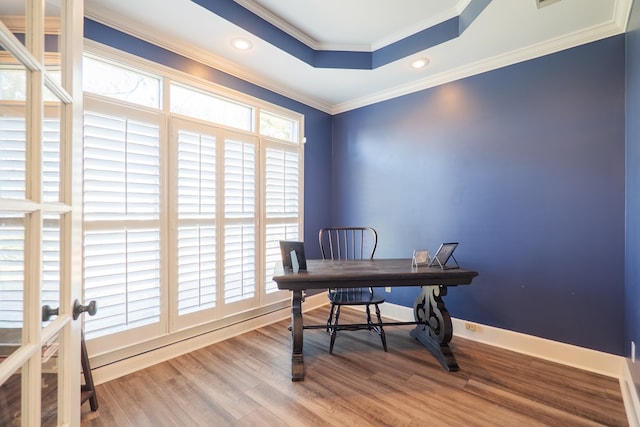 office area with baseboards, a raised ceiling, crown molding, and wood finished floors